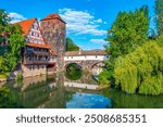 Historical old town with view of Weinstadel building, water tower, Henkerbrücke bridge and Henkerturm tower in Nürnberg, Germany..