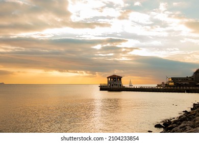 The historical pier in the Moda district of Kadikoy on Istanbul's Asian shore.  Cloudy orange sky. Calming coral color. Copy paste, text space. - Shutterstock ID 2104233854