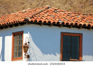 Historical Spanish Colonial building including a Spanish tile rooftop with arid mountains beyond taken in Palm Springs, CA  - Powered by Shutterstock