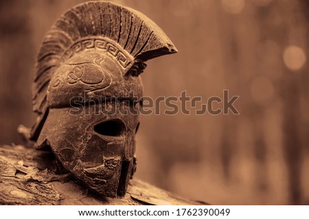 Historical Spartan soldier Helmet on forest background. roman Centurion gladiator  hardhat object. no people. Warriors History. Knight helmet heraldry armor medieval soldier ancient gladiator fighter