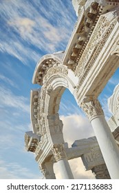 Historical Turkey Ephesus arch in an ancient city. Closeup of a keystone arch with architectural detail and patterns. Ruin of ancient roman archway temple outside under a blue sky with light clouds