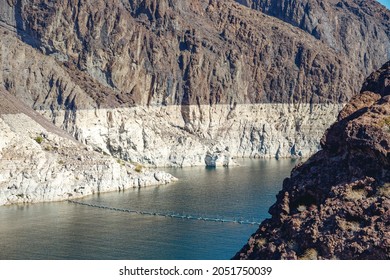 A Historically Low Water Level Of Hoover Dam And Lake Mead. Dark Rocks Blanched By White Calcium Ring Where The Water Level Once Was