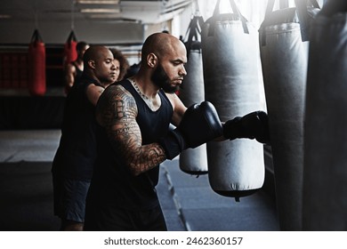 Hit, punching bag and man in boxing class for workout, challenge or competition training. Power, muscle and champion boxer in exercise with confidence, fitness gym and energy in MMA sports club. - Powered by Shutterstock