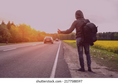 a hitchhiker catches a car on the road