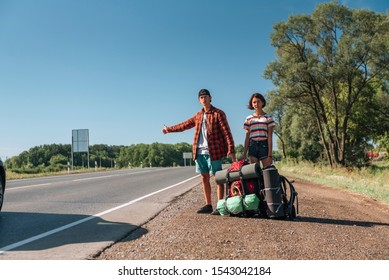 Hitchhiking Couple. Backpackers On Road.