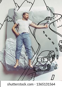 Hitch-hiking On The Road. Top View Photo Of Young Man Sleeping In A Big White Bed At Home. Dreams Concept. Painted Dream About Trip, Car, Way, Mountains, Nature, Journey, Driving, Summer, Tour.