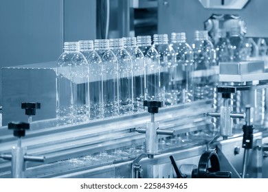 The hi-technology of drinking water manufacturing process. The  empty drinking water bottles  on the conveyor belt for filling process.  - Powered by Shutterstock