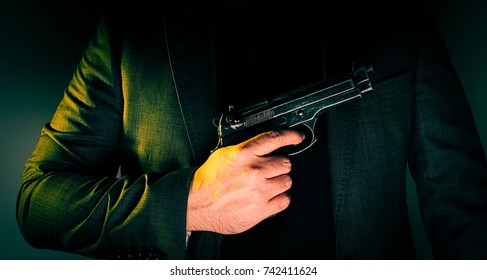 Hitman In Suit Holds Gun In Front Of Himself.