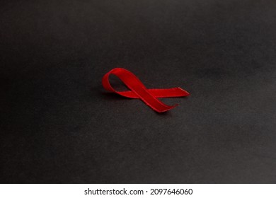 HIV AIDS Awareness Symbol Red Ribbon On Black Background