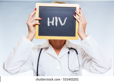 HIV Chalkboard Sign Held By Female Doctor In Front Of Face. - Powered by Shutterstock