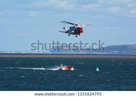 HM Coastguard helicopter on exercise with Beaumaris lifeboat on the Menai Strait off the coast of Anglesey