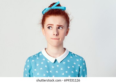 Hmm. Let Me Think. Isolated Studio Shot On Gray Background Of Cute Redhead Girl With Looking Sideways And Planning Something.