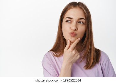 Hmm Let Me Think. Thoughtful Young Woman Rub Chin And Look Away While Thinking, Ponder Decision, Makes Choice, Stands In Summer T-shirt Against White Background