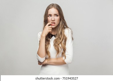 Hmm, Let's My Think. Confusion Beautiful Woman Touching Fingers Her Chin And Wondering. Studio Shot, Gray Background