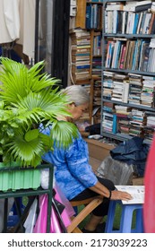 Ho Chi Minh city, Vietnam - August 2019: Woman reading book on street