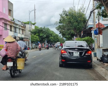 Ho Chi Minh City, Vietnam - 10 August 2022: People Is Riding Motorbikes Near A Car Park On A Street In Vietnam. Expensive Car. Own A Car Is A Dream To Many People In Vietnam.