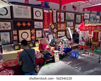 Ho Chi Minh city, Vietnam - Jan 22, 2016: : Atmosphere of springtime with colorful scene on Saigon street, Vietnamese woman in ao dai, posing beside flower to take photo on Tet holiday