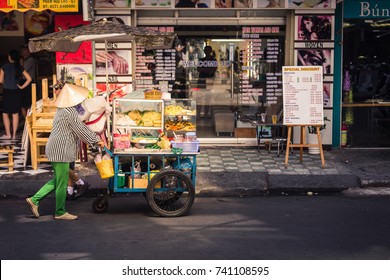 Ho Chi Minh City, Vietnam - January 02, 2016: A woman pushing a cart with food on a street in Ho Chi Minh City, Vietnam.