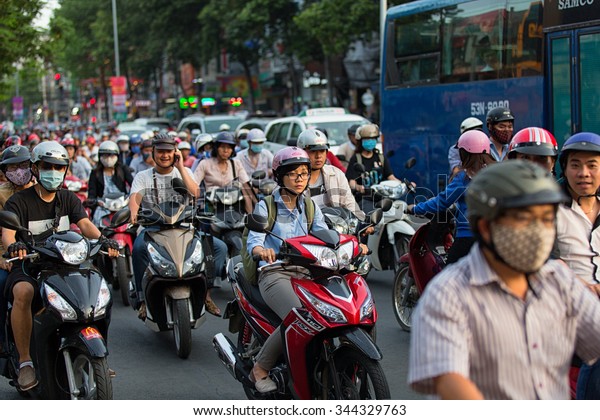 Ho Chi Minh city, Vietnam - April 19, 2015 :\
crowed scene of city traffic in rush hour, crowd of people wear\
helmet, transport by motorcycle, stop at red light in stress\
situation, Vietnam
