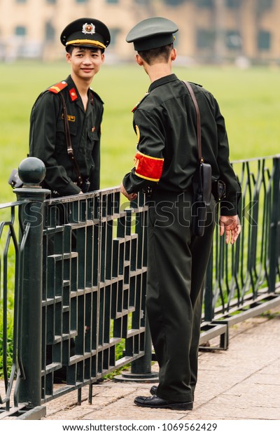 HO CHI MINH, VIETNAM. APRIL\
16, 2016: Vietnamese police officers talking with each other on the\
green field in front of Ho Chi Minh Mausoleum at Hanoi,\
Vietnam.