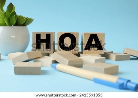 HOA blue background. text on wooden blocks near a potted plant
