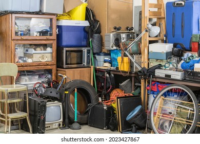 Hoarder Clutter And Household Junk Crowding The Corner Of A Messy Suburban Garage.  