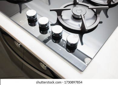 Hob cooker oven made of glass grill stainless steel control knobs selective focus over out of focus oven with burner on countertop made of ceramic stoneware background.