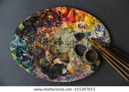 hobbies, work, art and life in different colors on a palette with a brush.
artist palette with a brush on grey background