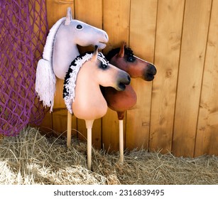 Hobby horses in the corral. Three hobby horse are waiting for the riders. Equestrian sports - Shutterstock ID 2316839495