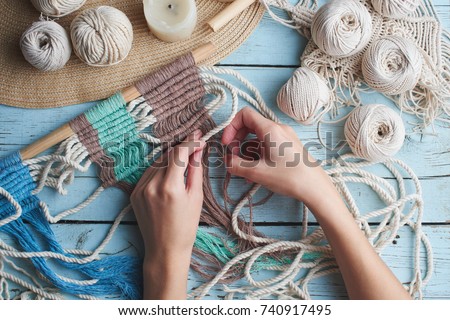 Hobby knitting macrame top view of the hand and thread on a wooden Board