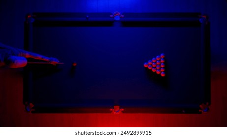 Hobby and leisure concept, billiard club scene shot. Top view of Russian billiard table in neon blue red light, man playing billiards.