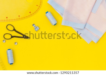 Hobby sewing with thread, scissors, fabric. Lifestyle. Yellow background top view mock up