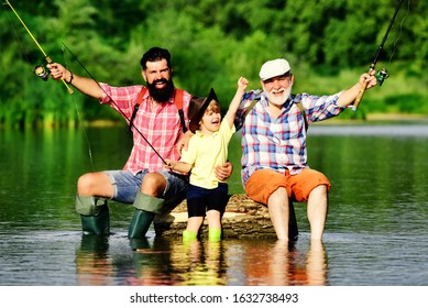 Hobby And Sport Activity. Happy People Family Have Fishing And Fun Together. Dad And Son Fishing At Lake. Grandpa And Grandson Are Fly Fishing On River