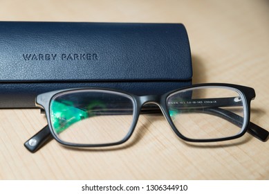 Hoboken NJ - February 5 2019: A pair of Warby Parker Wilkie glasses are shown with their case. The brand has become popular in the last few years due to their quite affordable eyeglass prices