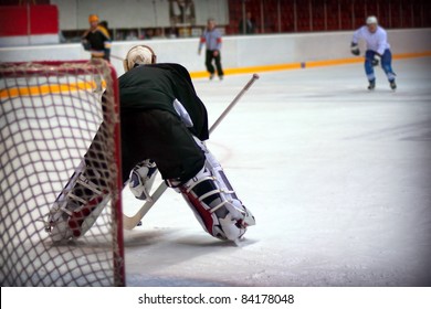 Hockey Goalie In Generic Black Equipment Protects Gate