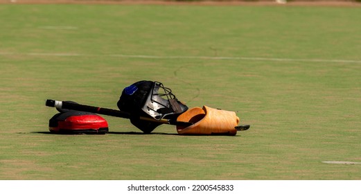 Hockey Helmet And Stick Lying On The Field Hockey Pitch