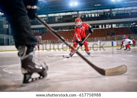 Hockey match at rink player in action kicking on goal