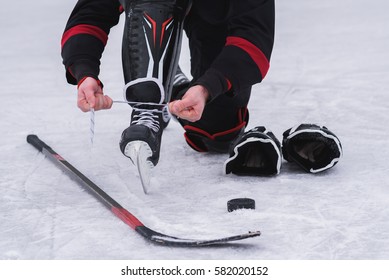 Hockey Player Before The Game Tying Laces On Skates