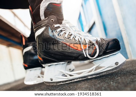 Hockey player feet in skates on the bench overboard are eagerly preparing to enter the game - player debut