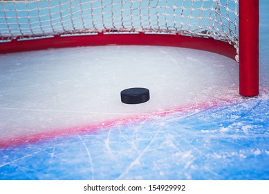 Hockey Puck Crossing Red Goal Line. Close View