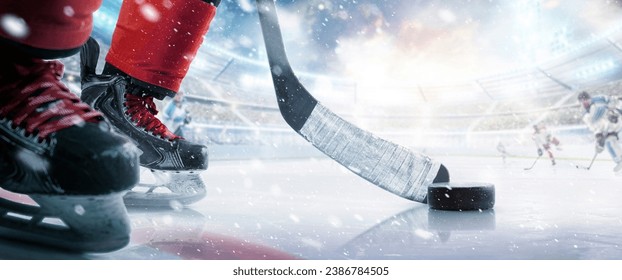 Hockey puck and stick close-up. Hockey player in ice arena. Focus on the puck. Hockey concept. Ice. Hockey stadium