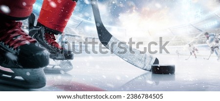 Hockey puck and stick close-up. Hockey player in ice arena. Focus on the puck. Hockey concept. Ice. Hockey stadium