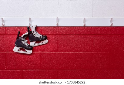 Hockey Skates Hanging Over Red Wall In Locker Room With Copy Space