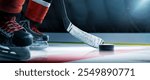 Hockey skates, puck and stick close-up. Focus on the puck. Red hockey player in ice arena. Hockey concept. Ice. Hockey arena