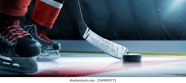 Hockey skates, puck and stick close-up. Focus on the puck. Red hockey player in ice arena. Hockey concept. Ice. Hockey arena