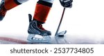 Hockey skates, stick and puck close-up. Hockey player in ice rink. Focus on the puck. Hockey player in action. Ice. Isolated