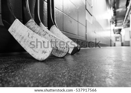 Hockey stick blades laid on a dirty arena floor - Shallow depth of field - Black and white