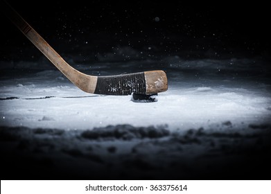 Hockey Stick and Puck on the Ice Rink