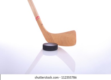 Hockey stick and puck on white background with reflection