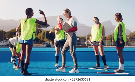 Hockey, women team with coach and sport, high five and coaching with game strategy, training and fitness on turf outdoor. Athlete stretching, start practice and wellness, motivation and support - Powered by Shutterstock